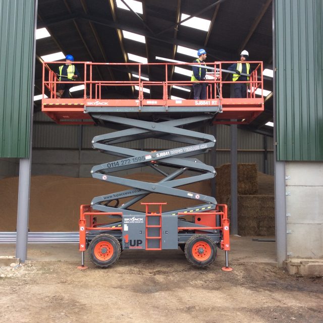 Engineers up a scissor lift fitting a new shutter